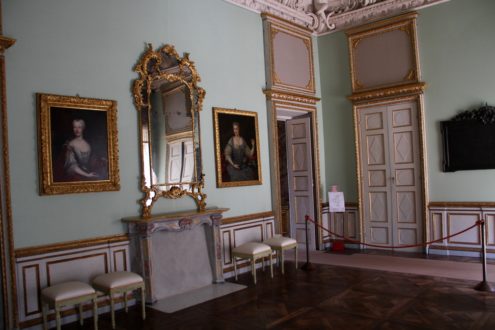 Villa della Regina_025.JPG - Anticamera verso levante.La sala, dedicata allo svago, nel Settecento ospitava tavoli da gioco e accessori per giochi di società; sulle pareti erano esposti dipinti di vari formati e soggetti. La sala si presenta come il risultato di successivi interventi commissionati da Anna Maria d'Orléans e da Carlo Emanuele III. Alla prima fase risale la volta in stucco, alla seconda le boiserie e le tele raffiguranti Giochi di putti di Giovanni Battista Crosato; sono invece perdute le sei tele con episodi mitologici. Risalgono al periodo dell'istituto per le Figlie dei Militari il Ritratto di Umberto i e la lapide in bronzo che riporta il bollettino con cui il generale Armando Diaz comunicò la fine della Prima Guerra Mondiale nel 1918. 